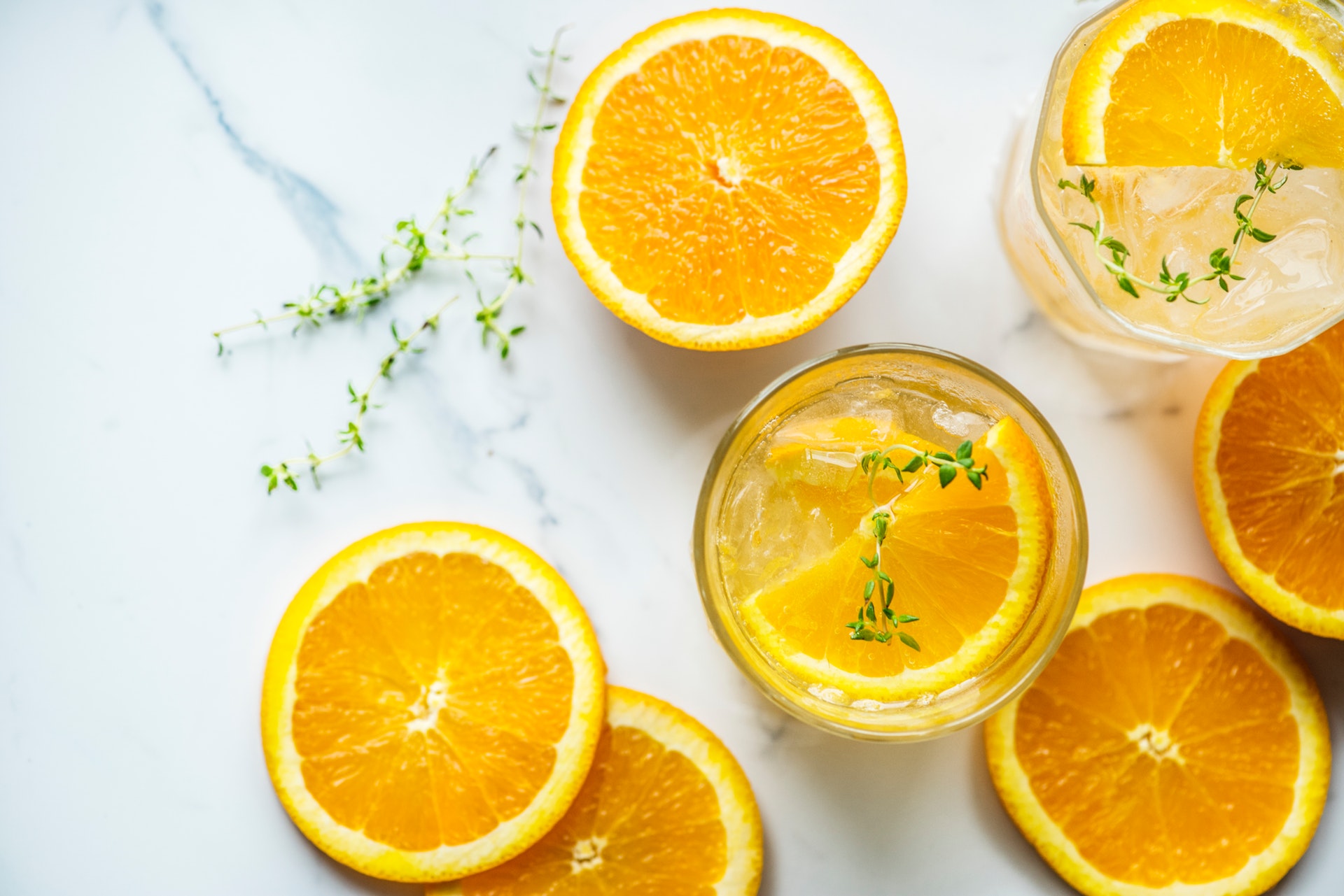 Halved oranges on a table with a glass of water