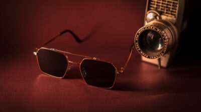 glasses next to an old camera