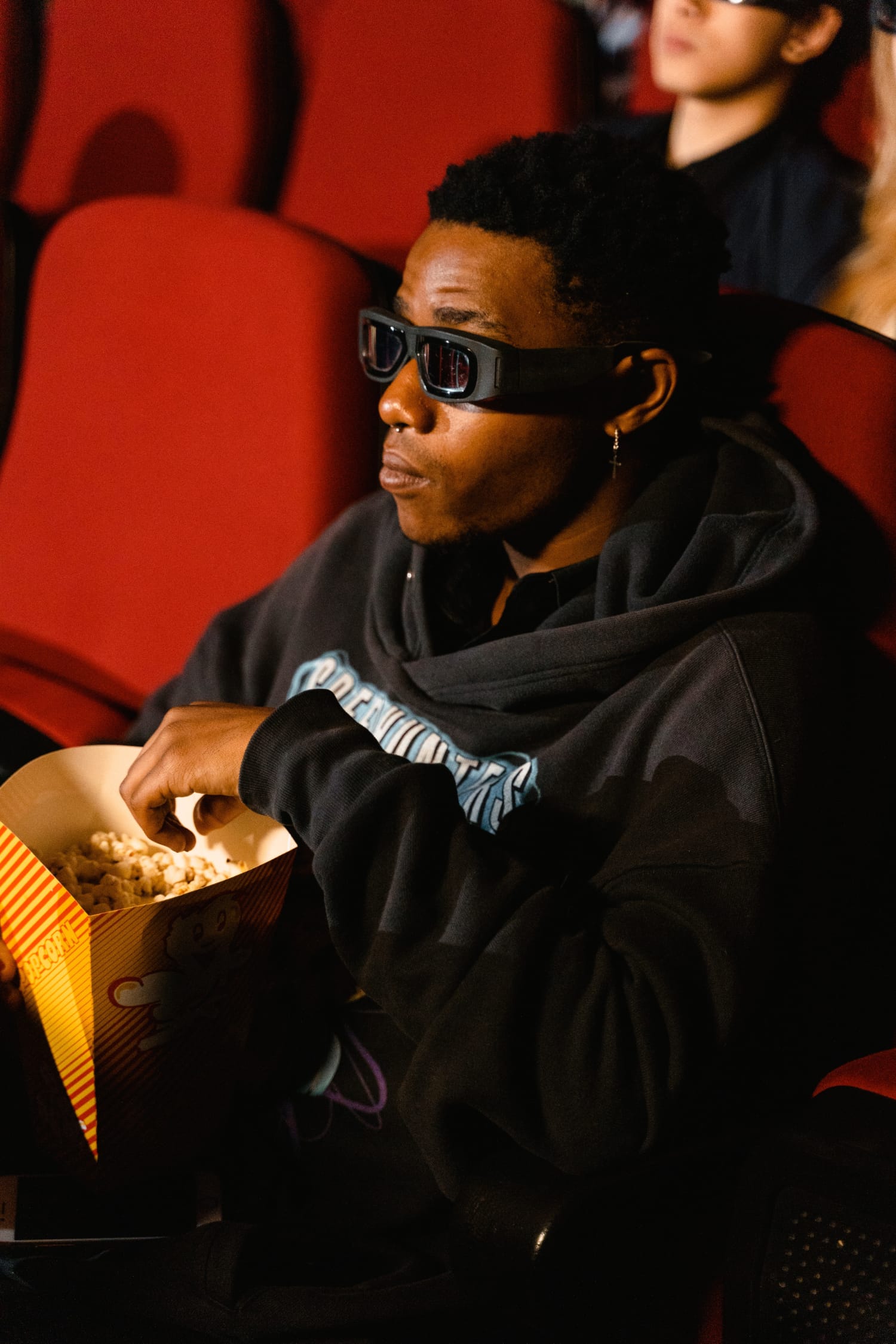 guy sitting the cinema wearing glasses