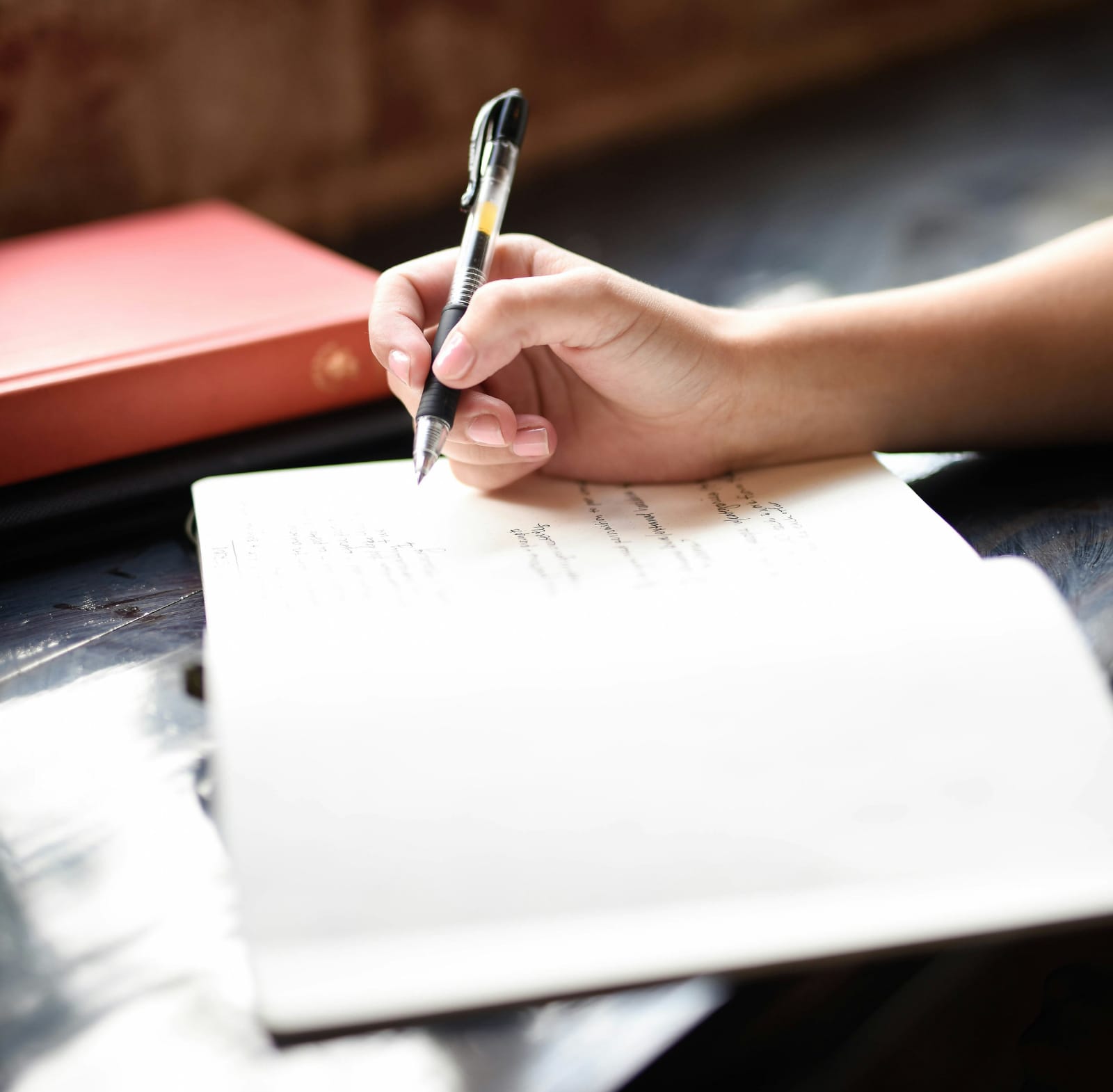 woman writing a review about buying glasses online in a notebook